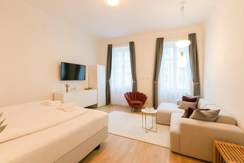 Mini Mint — studio overview with bed, sofa and tall windows